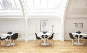 room with three tables with chairs, skylight and hardwood floor